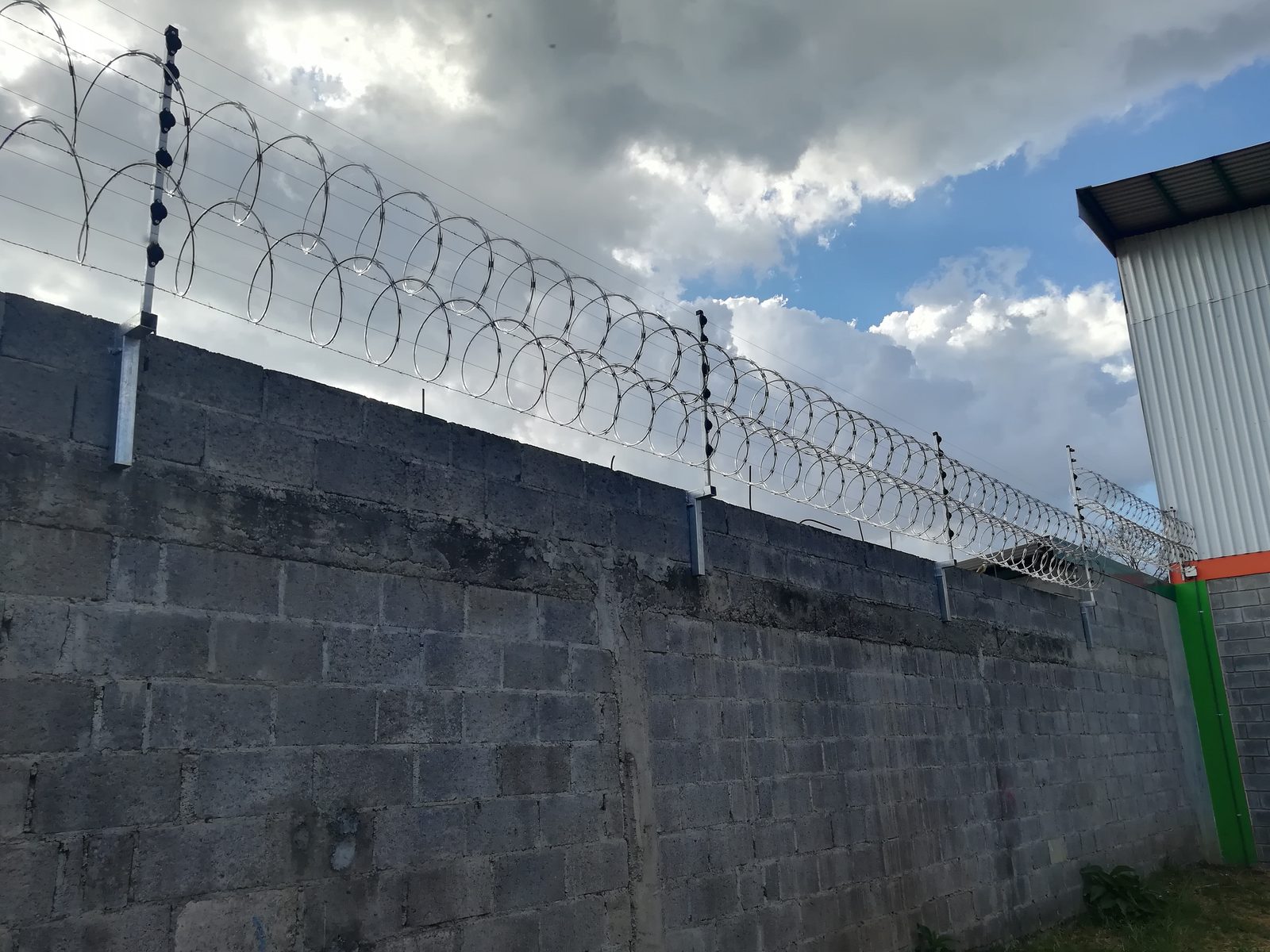 Cerca eléctrica instalada sobre muro de vivienda moderna